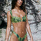 Woman wearing a green bikini set against a rocky background