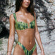 Woman wearing a green bikini set against a rocky background