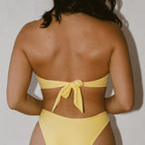 Sophia wearing a yellow bikini against a plain background